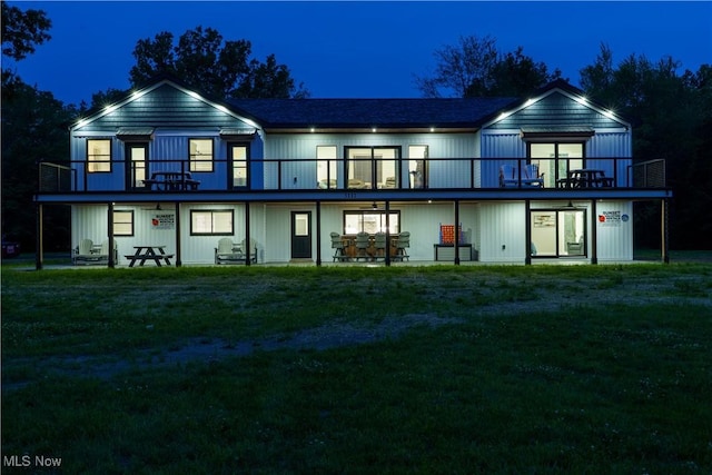 5111 N Myers Rd, Geneva, OH 44041 - back of house at night featuring a lawn and a balcony