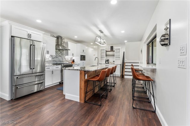 5111 N Myers Rd, Geneva, OH 44041 - kitchen featuring high quality appliances, wall chimney range hood, dark wood finished floors, white cabinets, and recessed lighting