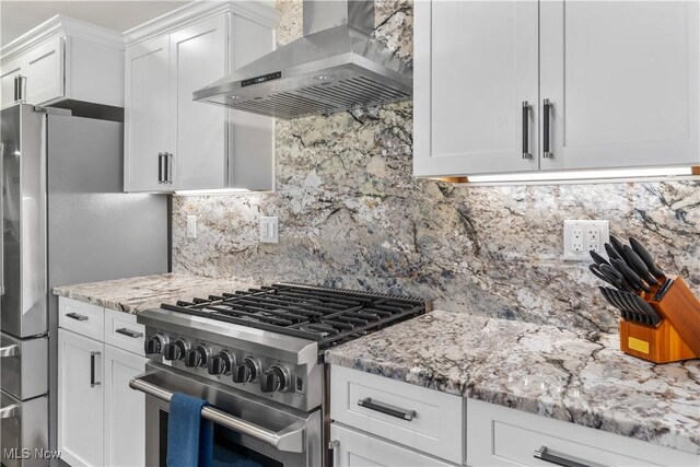 5111 N Myers Rd, Geneva, OH 44041 - kitchen featuring wall chimney exhaust hood, stainless steel appliances, light stone countertops, white cabinets, and decorative backsplash