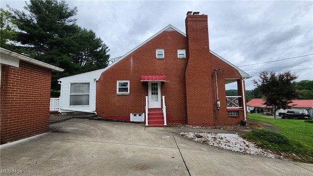 138 Marsha St, Weirton, WV 26062 - view of property exterior featuring a chimney, brick siding, and entry steps