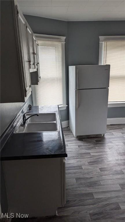 3821 E 55th St, Cleveland, OH 44105 - kitchen featuring freestanding refrigerator, dark wood-style flooring, and dark countertops