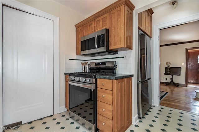 3336 Daleford Rd, Shaker Heights, OH 44120 - kitchen with stainless steel appliances, light floors, brown cabinets, dark countertops, and backsplash