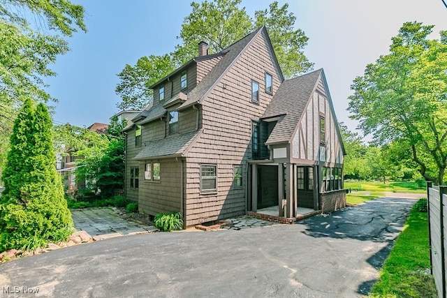 3336 Daleford Rd, Shaker Heights, OH 44120 - view of side of home featuring a patio, a shingled roof, and a chimney