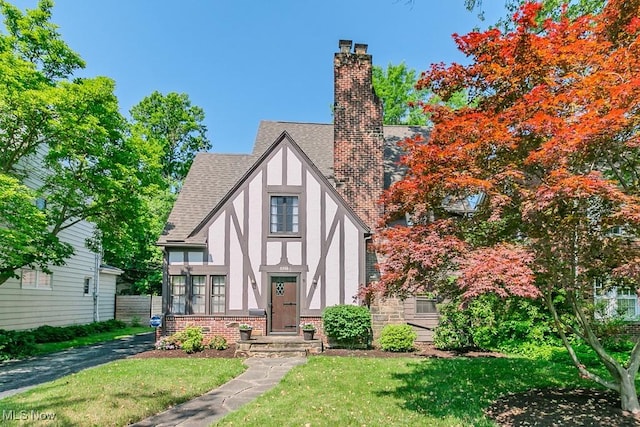 3336 Daleford Rd, Shaker Heights, OH 44120 - view of front facade featuring stucco siding, a chimney, roof with shingles, and a front lawn