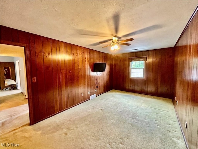 930 Pearson Cir Unit 4, Youngstown, OH 44512 - carpeted empty room featuring ceiling fan, wooden walls, and a textured ceiling