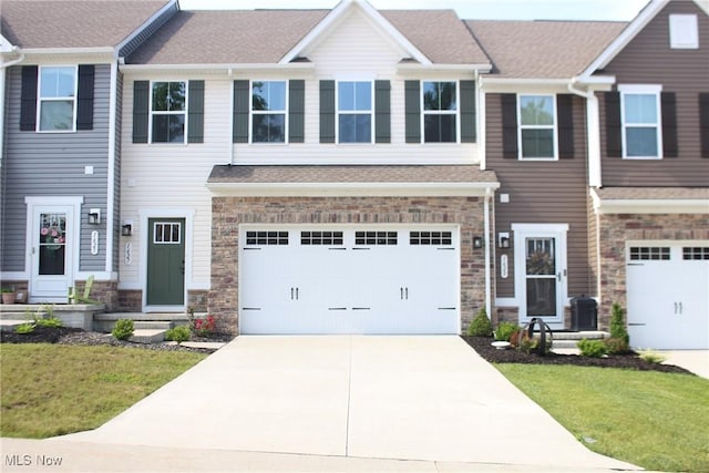 1627 Cypress Rd, Stow, OH 44224 - townhome / multi-family property featuring concrete driveway, stone siding, and a front yard
