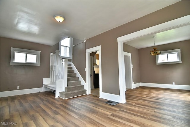1134 Auburn Pl NW, Canton, OH 44703 - unfurnished living room with stairs, wood finished floors, and healthy amount of natural light