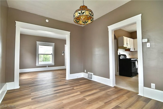 1134 Auburn Pl NW, Canton, OH 44703 - unfurnished dining area featuring light wood-type flooring and baseboards
