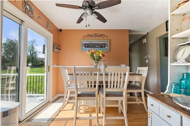 11576 Peach Glen Ave NW, Uniontown, OH 44685 - dining space featuring light wood finished floors, ceiling fan, and a textured ceiling