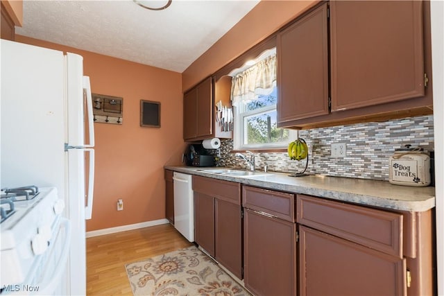 11576 Peach Glen Ave NW, Uniontown, OH 44685 - kitchen featuring white range with gas cooktop, dishwasher, decorative backsplash, light wood-type flooring, and light countertops