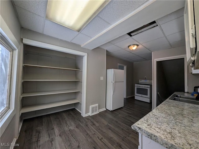 3947 W 22nd St, Cleveland, OH 44109 - kitchen featuring white appliances, a paneled ceiling, dark wood-style flooring, light countertops, and white cabinets