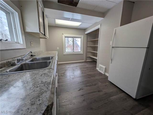 3947 W 22nd St, Cleveland, OH 44109 - kitchen with freestanding refrigerator, dark wood-style floors, a paneled ceiling, light countertops, and built in features