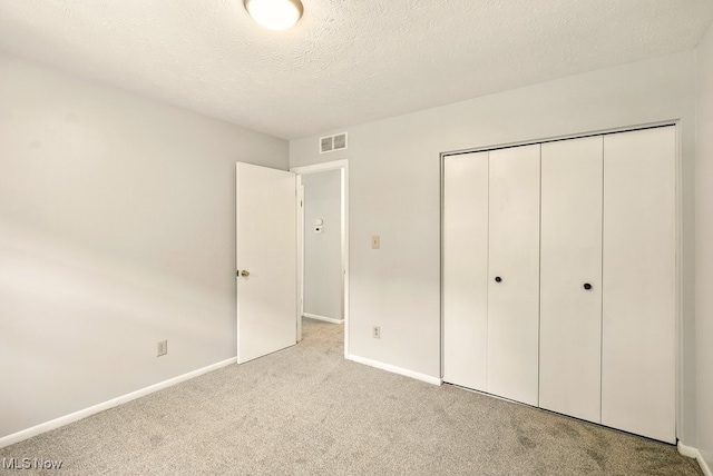 3820 Twin Pines Dr Unit 8A, Uniontown, OH 44685 - unfurnished bedroom featuring carpet, a closet, and a textured ceiling