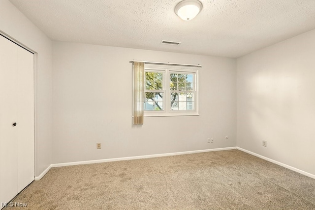 3820 Twin Pines Dr Unit 8A, Uniontown, OH 44685 - unfurnished bedroom featuring carpet, a textured ceiling, and a closet