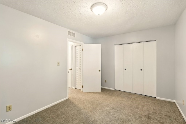 3820 Twin Pines Dr Unit 8A, Uniontown, OH 44685 - unfurnished bedroom featuring carpet flooring, a closet, and a textured ceiling