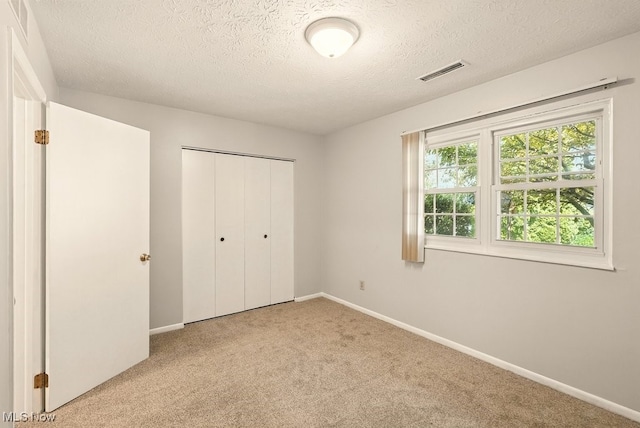 3820 Twin Pines Dr Unit 8A, Uniontown, OH 44685 - unfurnished bedroom with carpet flooring, a textured ceiling, and a closet