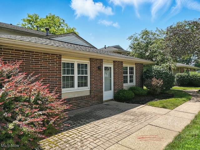 3820 Twin Pines Dr Unit 8A, Uniontown, OH 44685 - view of front of property featuring a patio, brick siding, and roof with shingles