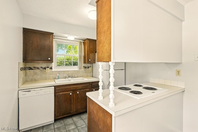 3820 Twin Pines Dr Unit 8A, Uniontown, OH 44685 - kitchen with white appliances, light countertops, decorative backsplash, light tile patterned floors, and a peninsula