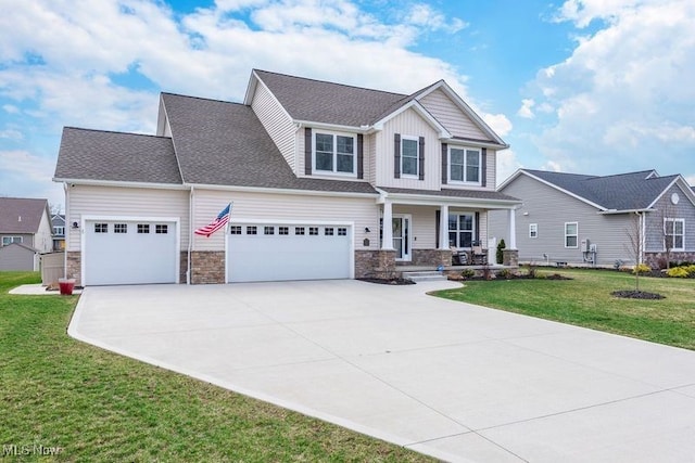 12187 Bexley Dr, Grafton, OH 44044 - craftsman-style house with covered porch, driveway, stone siding, and a garage