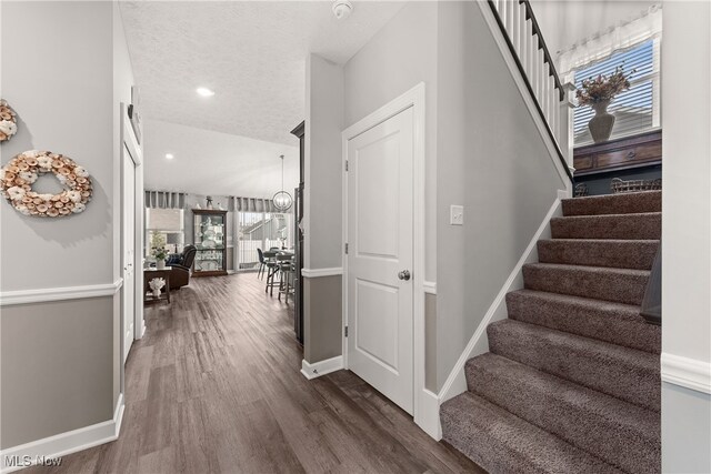 12187 Bexley Dr, Grafton, OH 44044 - staircase with wood finished floors, recessed lighting, and a textured ceiling