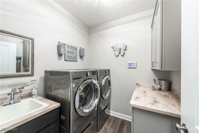 12187 Bexley Dr, Grafton, OH 44044 - laundry room with cabinet space, washing machine and clothes dryer, dark wood-style floors, and a textured ceiling