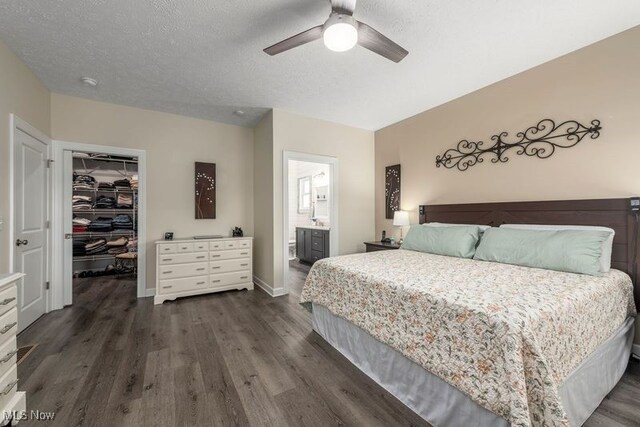 12187 Bexley Dr, Grafton, OH 44044 - bedroom featuring a walk in closet, dark wood-style flooring, a closet, ceiling fan, and ensuite bathroom