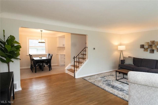 341 Clarmont Rd, Willowick, OH 44095 - living room with stairway, wood finished floors, arched walkways, and a chandelier