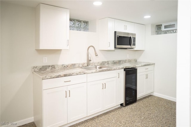 341 Clarmont Rd, Willowick, OH 44095 - kitchen with stainless steel microwave, white cabinetry, light countertops, recessed lighting, and beverage cooler