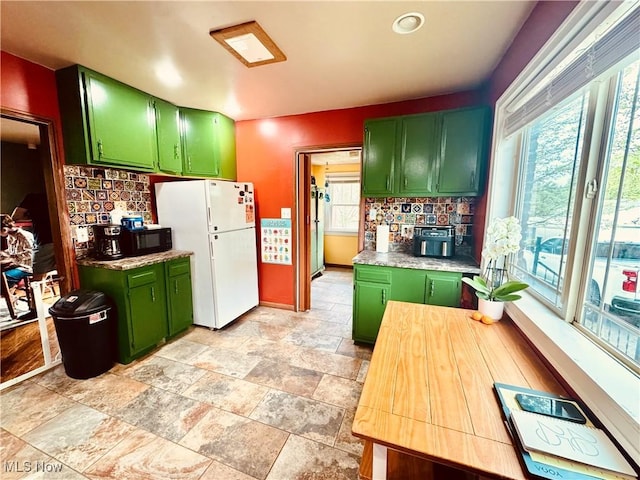 741 Jennings Ave, Salem, OH 44460 - kitchen with green cabinets, freestanding refrigerator, plenty of natural light, and decorative backsplash