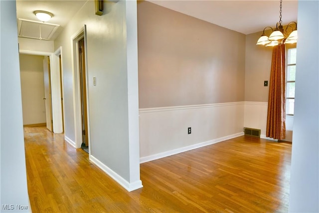 2803 Brunswick Rd, Youngstown, OH 44511 - empty room with attic access, wood finished floors, and a chandelier