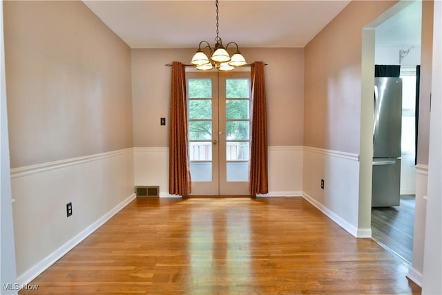 2803 Brunswick Rd, Youngstown, OH 44511 - unfurnished dining area featuring wood finished floors, a chandelier, and french doors