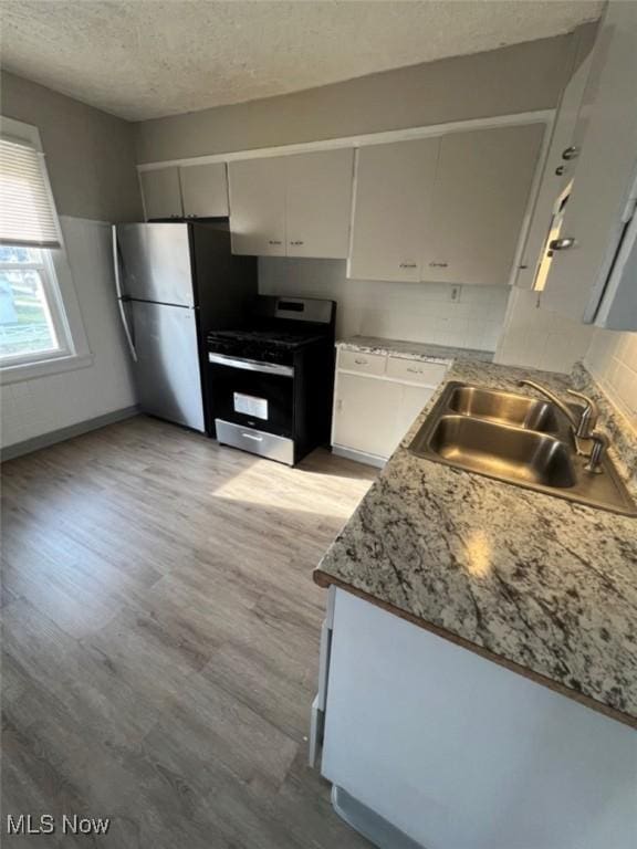 836 E 236th St, Euclid, OH 44123 - kitchen with stainless steel appliances, a textured ceiling, light wood-style floors, and light countertops