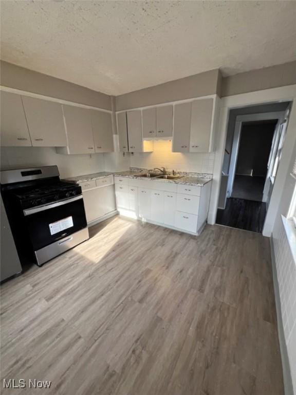 836 E 236th St, Euclid, OH 44123 - kitchen with stainless steel range with gas cooktop, light wood finished floors, a textured ceiling, and dishwasher