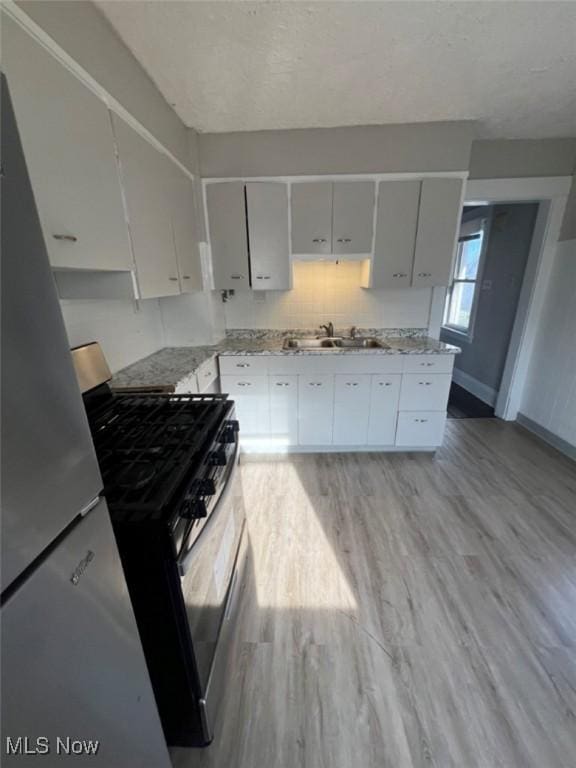 836 E 236th St, Euclid, OH 44123 - kitchen with stainless steel range with gas cooktop, light wood-type flooring, and light stone countertops