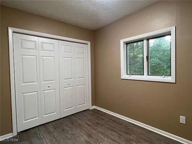 213 Turner Dr, Chardon, OH 44024 - unfurnished bedroom with dark wood-style flooring, a textured ceiling, and a closet