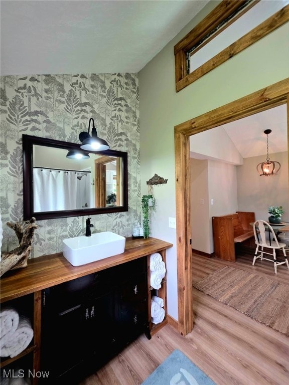 12779 State Route 700, Hiram, OH 44234 - bathroom with wallpapered walls, an accent wall, vanity, and wood finished floors
