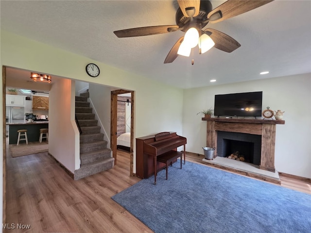 12779 State Route 700, Hiram, OH 44234 - living room featuring stairway, wood finished floors, a premium fireplace, ceiling fan, and recessed lighting