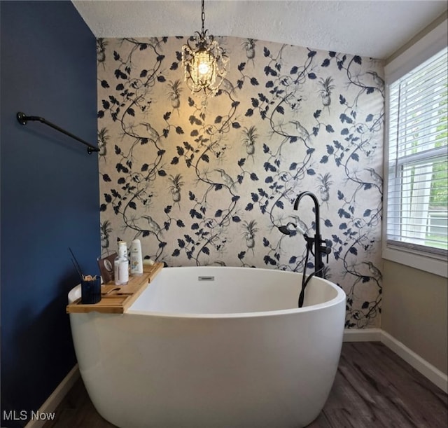 12779 State Route 700, Hiram, OH 44234 - full bathroom featuring a soaking tub, a textured ceiling, healthy amount of natural light, and wood finished floors