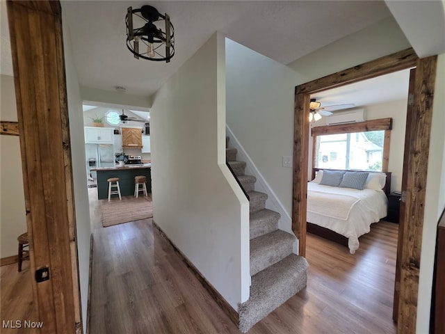 12779 State Route 700, Hiram, OH 44234 - stairs featuring ceiling fan, a wall mounted AC, and wood finished floors