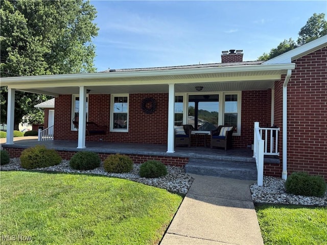 203 Park Ave, Middlebourne, WV 26149 - property entrance with covered porch, a chimney, brick siding, and a yard