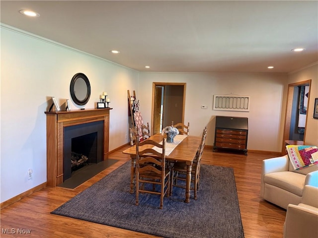 203 Park Ave, Middlebourne, WV 26149 - dining area featuring ornamental molding, recessed lighting, a fireplace with flush hearth, and wood finished floors