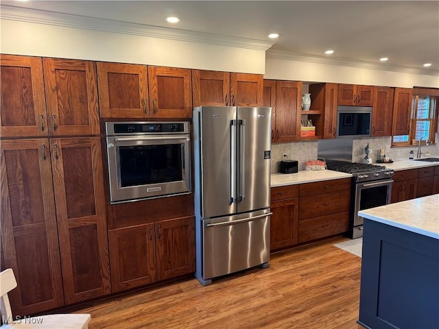 203 Park Ave, Middlebourne, WV 26149 - kitchen with appliances with stainless steel finishes, open shelves, light countertops, light wood finished floors, and crown molding
