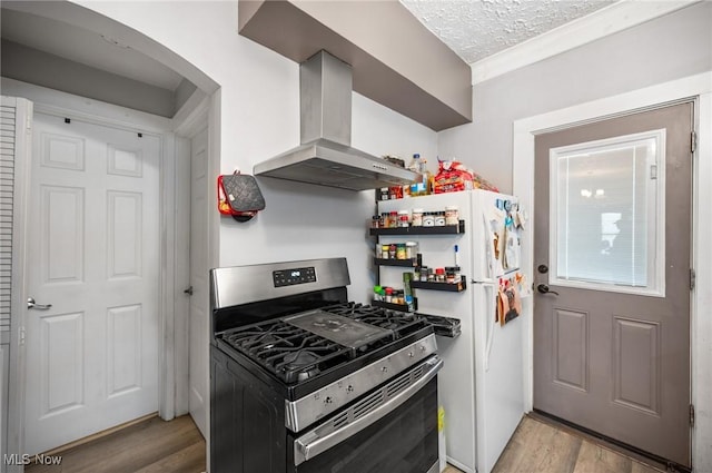 301 Pennsylvania Ave, Ashtabula, OH 44004 - kitchen featuring stainless steel gas stove, exhaust hood, light wood-type flooring, arched walkways, and a textured ceiling
