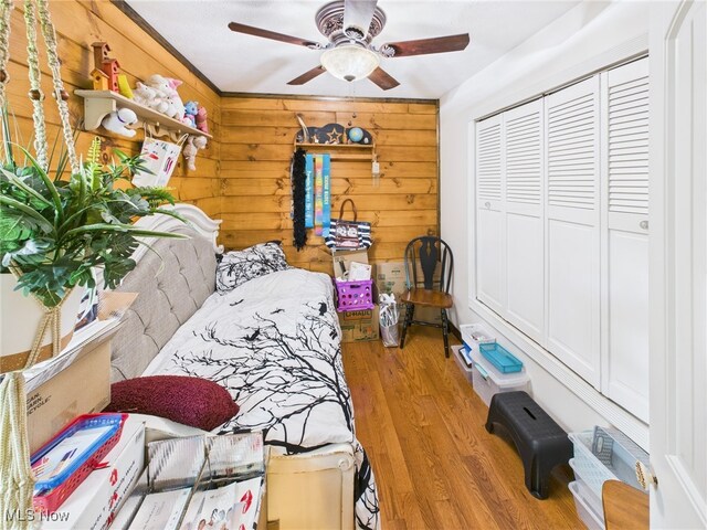 9246 State Route 555, Cutler, OH 45724 - bedroom featuring wood finished floors, a closet, wooden walls, and ceiling fan