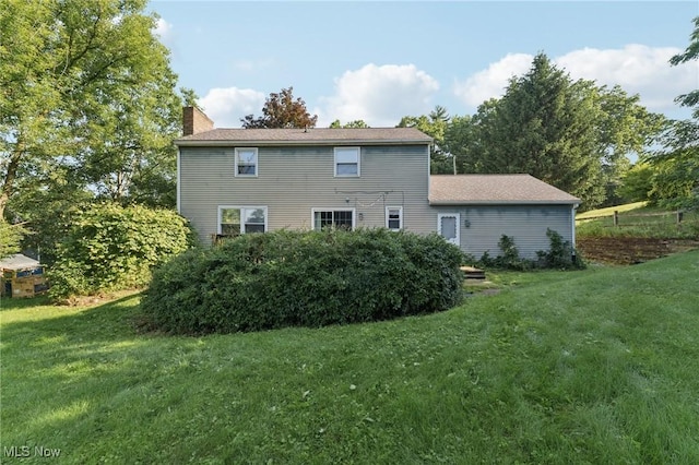 3594 Heckman St NW, Uniontown, OH 44685 - back of house featuring a chimney and a lawn