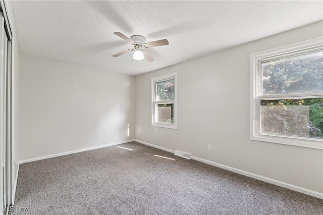 3594 Heckman St NW, Uniontown, OH 44685 - empty room with a ceiling fan, carpet flooring, and a textured ceiling