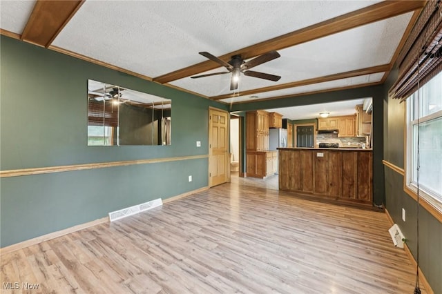 3594 Heckman St NW, Uniontown, OH 44685 - unfurnished living room with a ceiling fan, light wood-type flooring, beam ceiling, and a textured ceiling