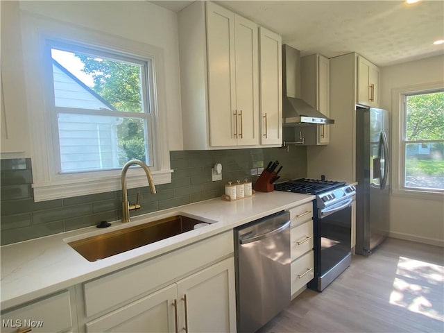 109 Avalon Ave, Bedford, OH 44146 - kitchen with stainless steel appliances, wall chimney range hood, light wood finished floors, decorative backsplash, and recessed lighting