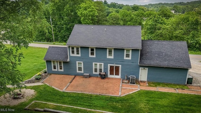 1310 Oxbow Rd, Belpre, OH 45714 - back of house with a patio area, a view of trees, a lawn, and a shingled roof