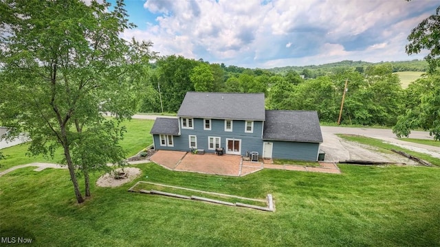 1310 Oxbow Rd, Belpre, OH 45714 - rear view of house with a patio area, a lawn, roof with shingles, and a view of trees